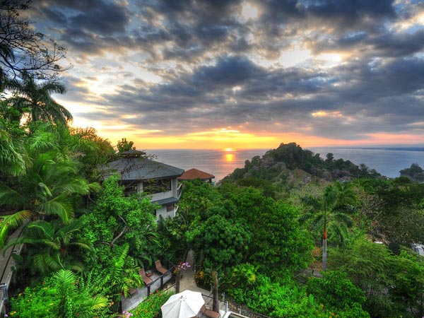 A photo of the Costa Rica landscape with the sun setting in the background.