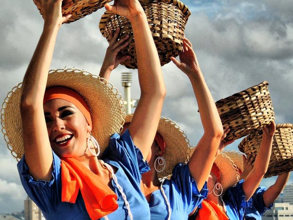 Costa Rica women wearing traditional clothing and raising baskets